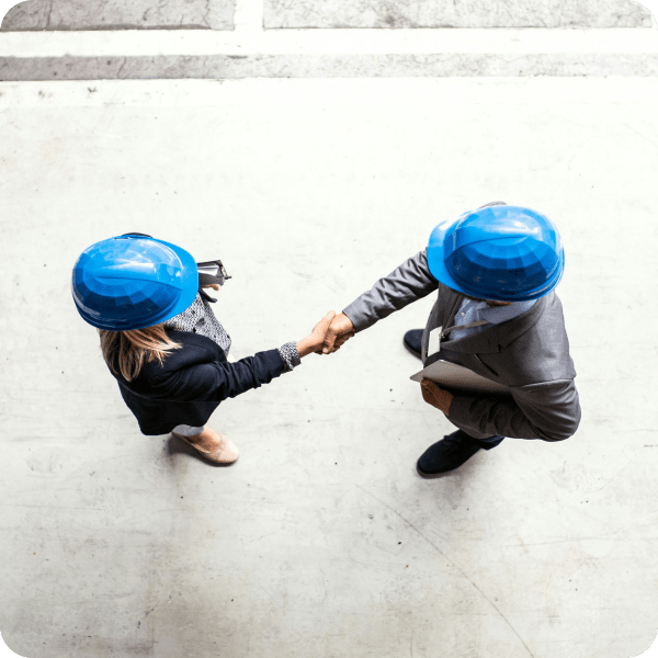 Construction document management software with two people wearing hard hats shaking hands.